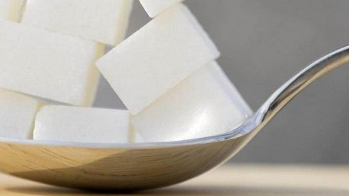 Löffel mit Zuckerwürfeln in Perspektive.