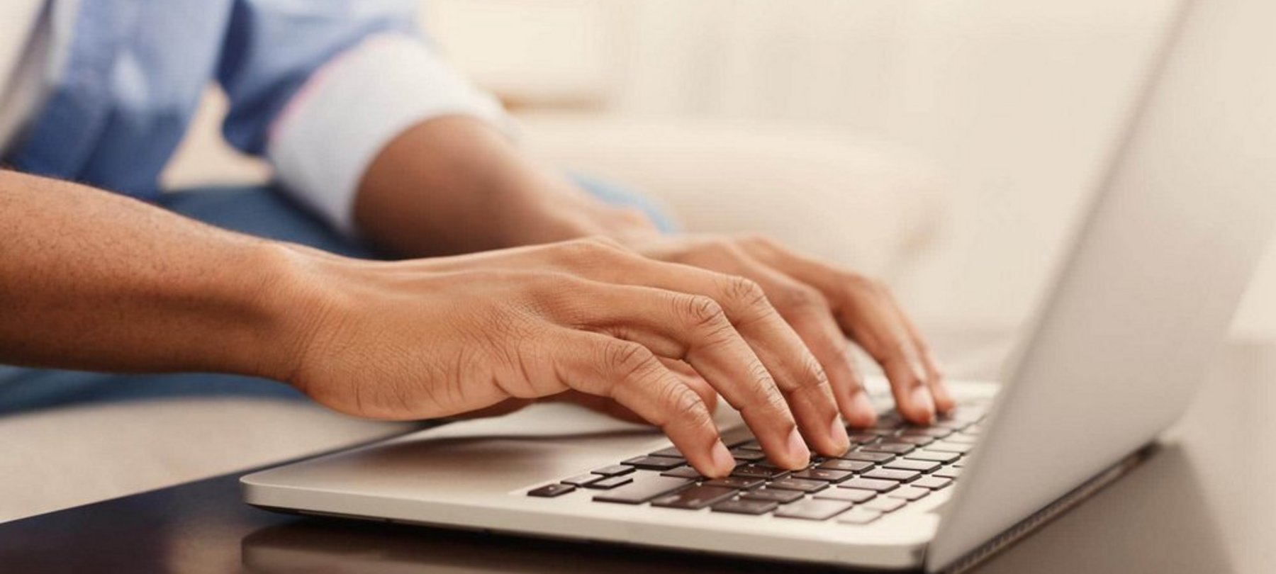 Hand am Laptop sendet Online-Meldung ab - digitale Kommunikation.