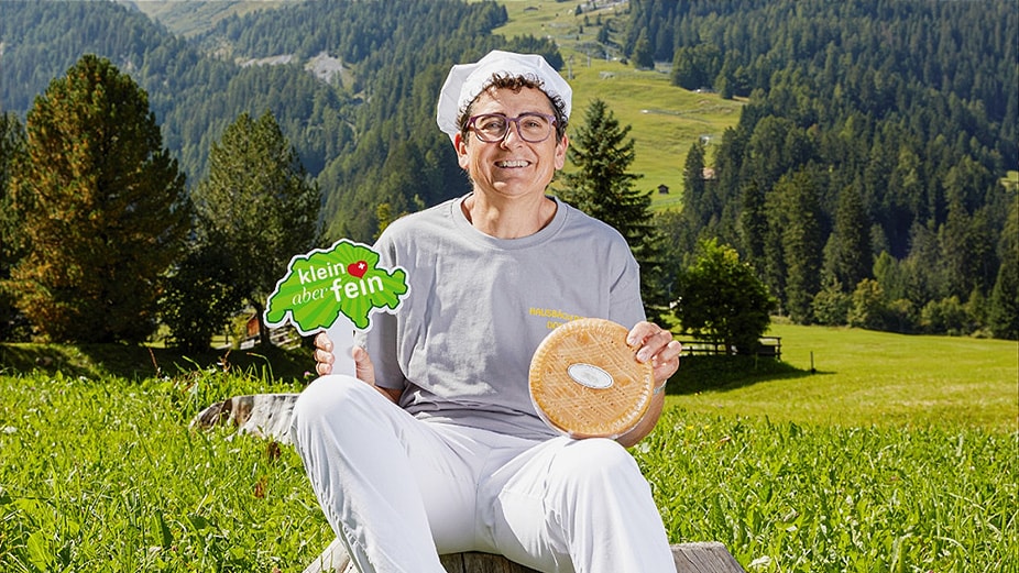 Homme avec l'étiquette « petit mais raffiné » avec une meule de fromage.