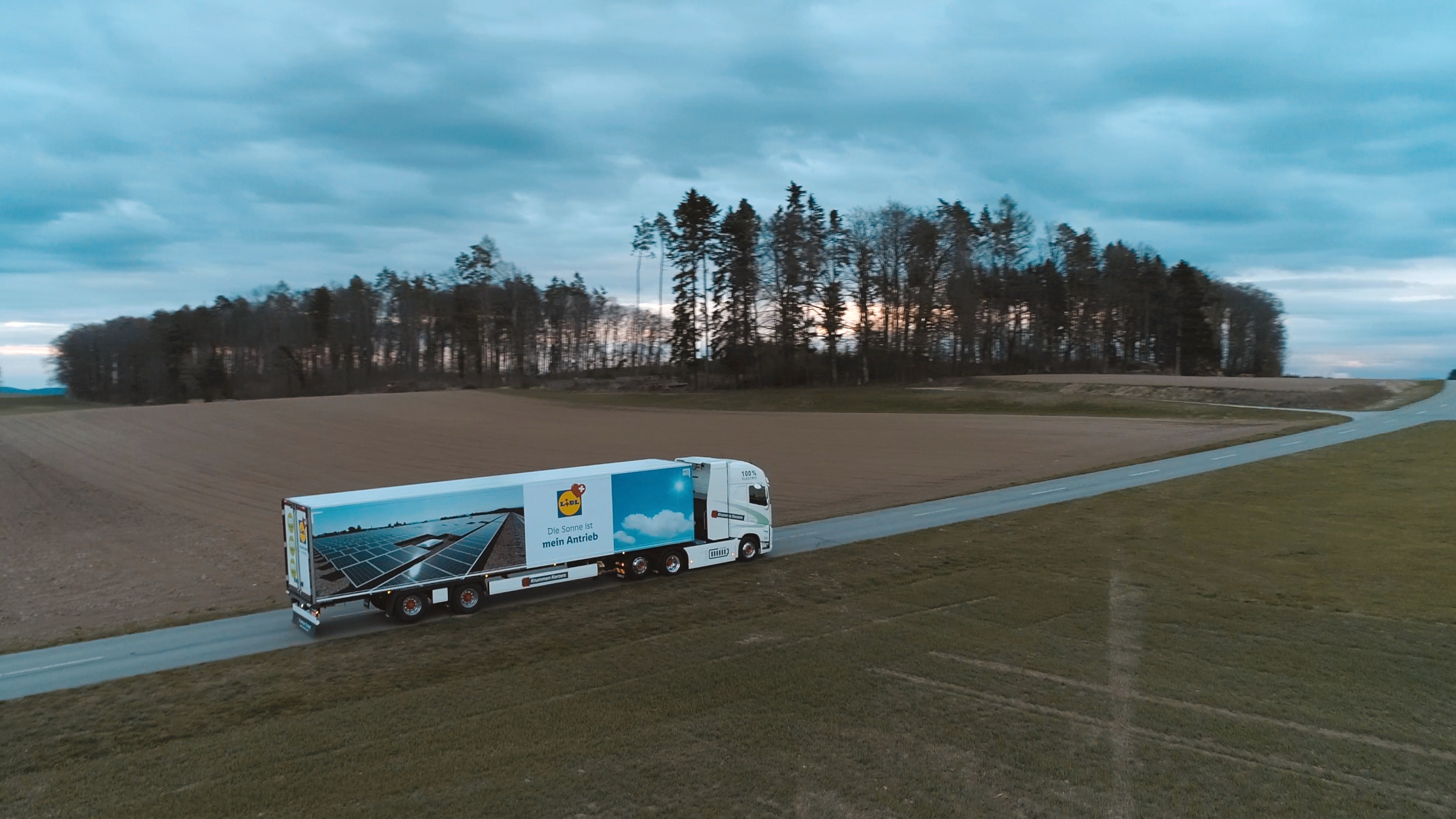 Vista aerea: camion Lidl solare che attraversa paesaggio naturale.