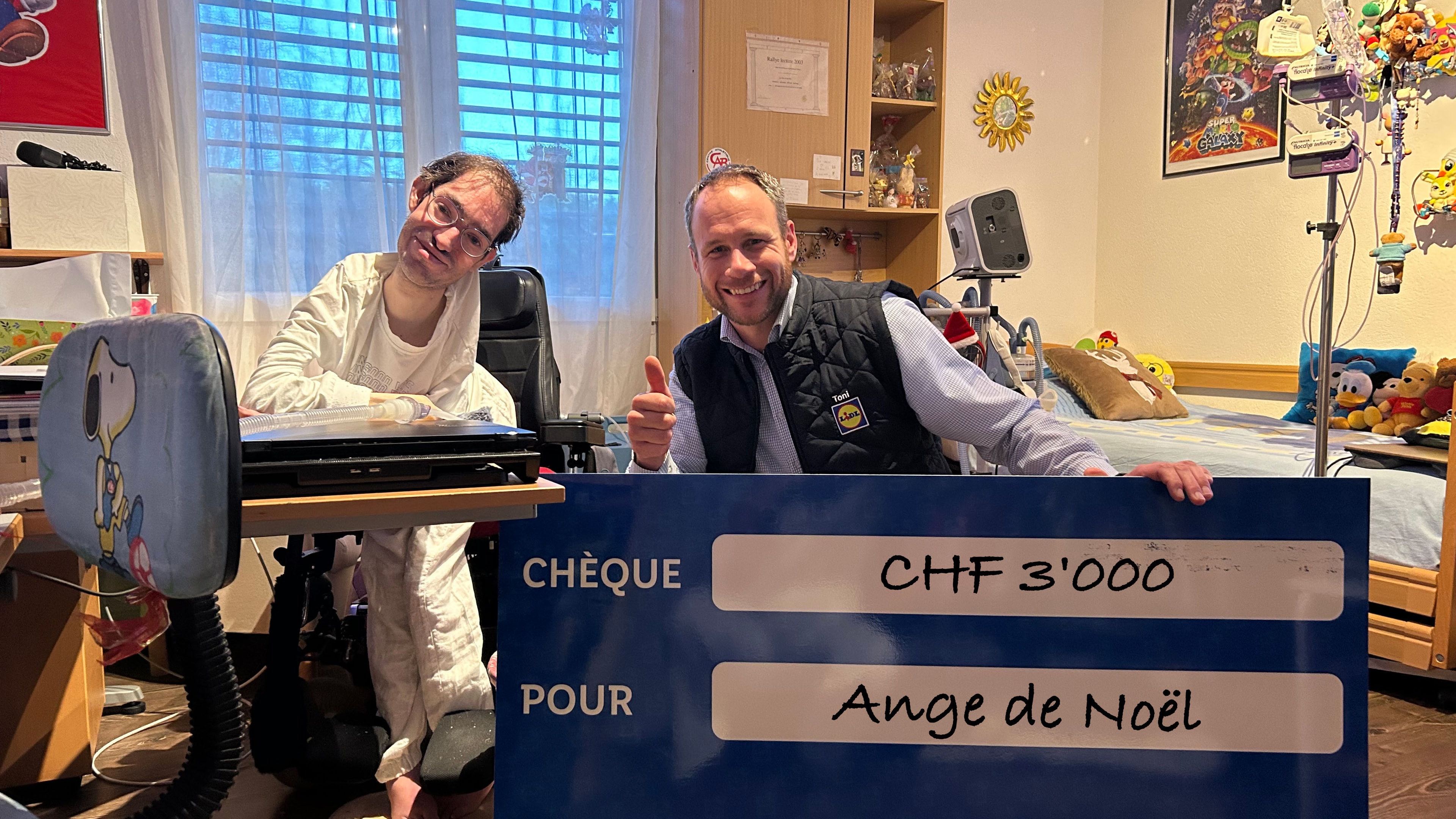 Übergabe eines blauen Schecks an Ange de Noël über einen Betrag von 3000 Franken.