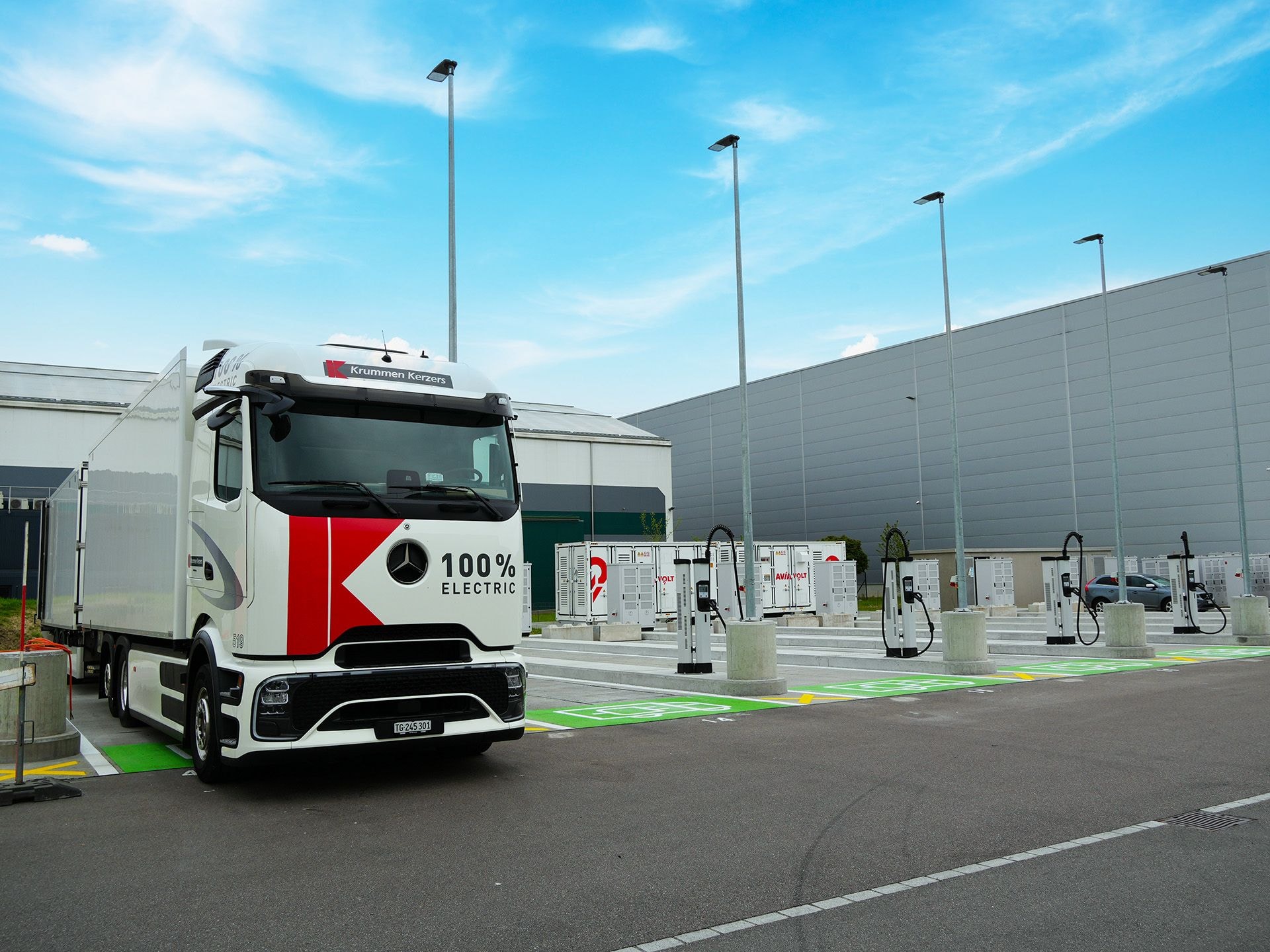 Grosser weisser Lkw mit roten Designelementen steht auf einem elektroparkplatz