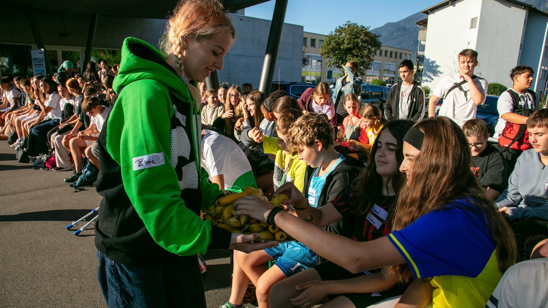 Una collaboratrice di GORILLA distribuisce banane di freschezza agli scolari