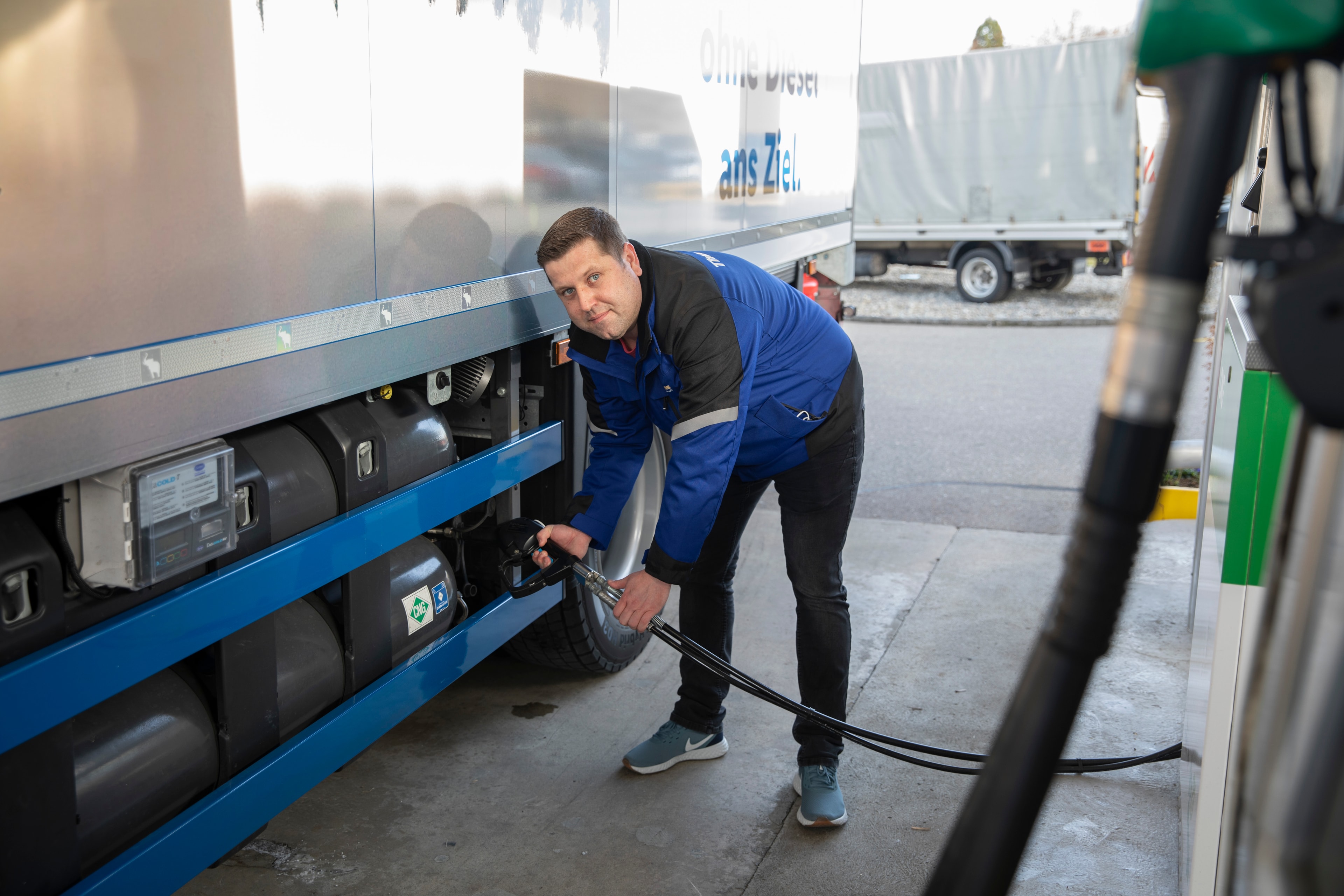 Eine Person betank einen LKW mit Biogas
