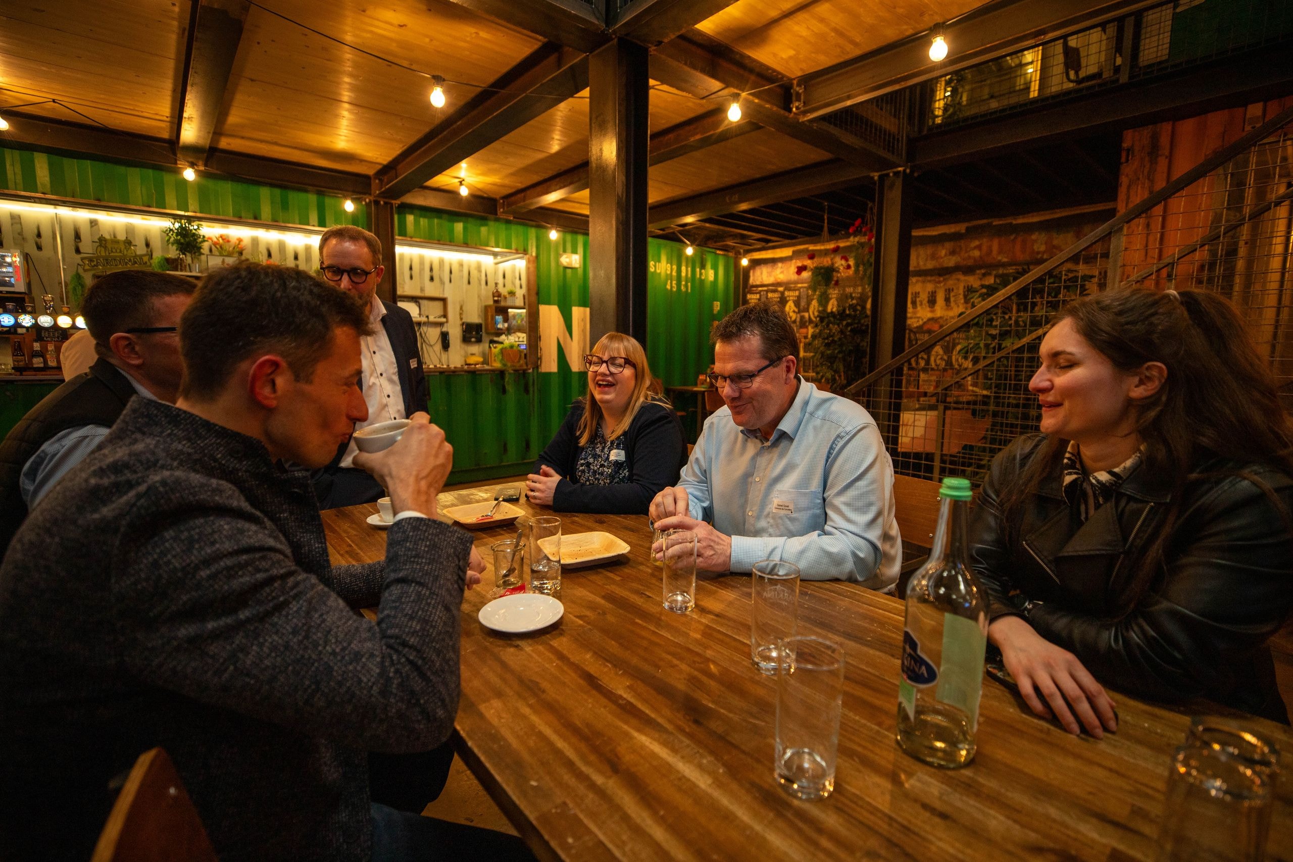 Teilnehmende des Stakeholder-Dialogs tauschen sich beim informellen Networking an einem Tisch aus und pflegen den Dialog.