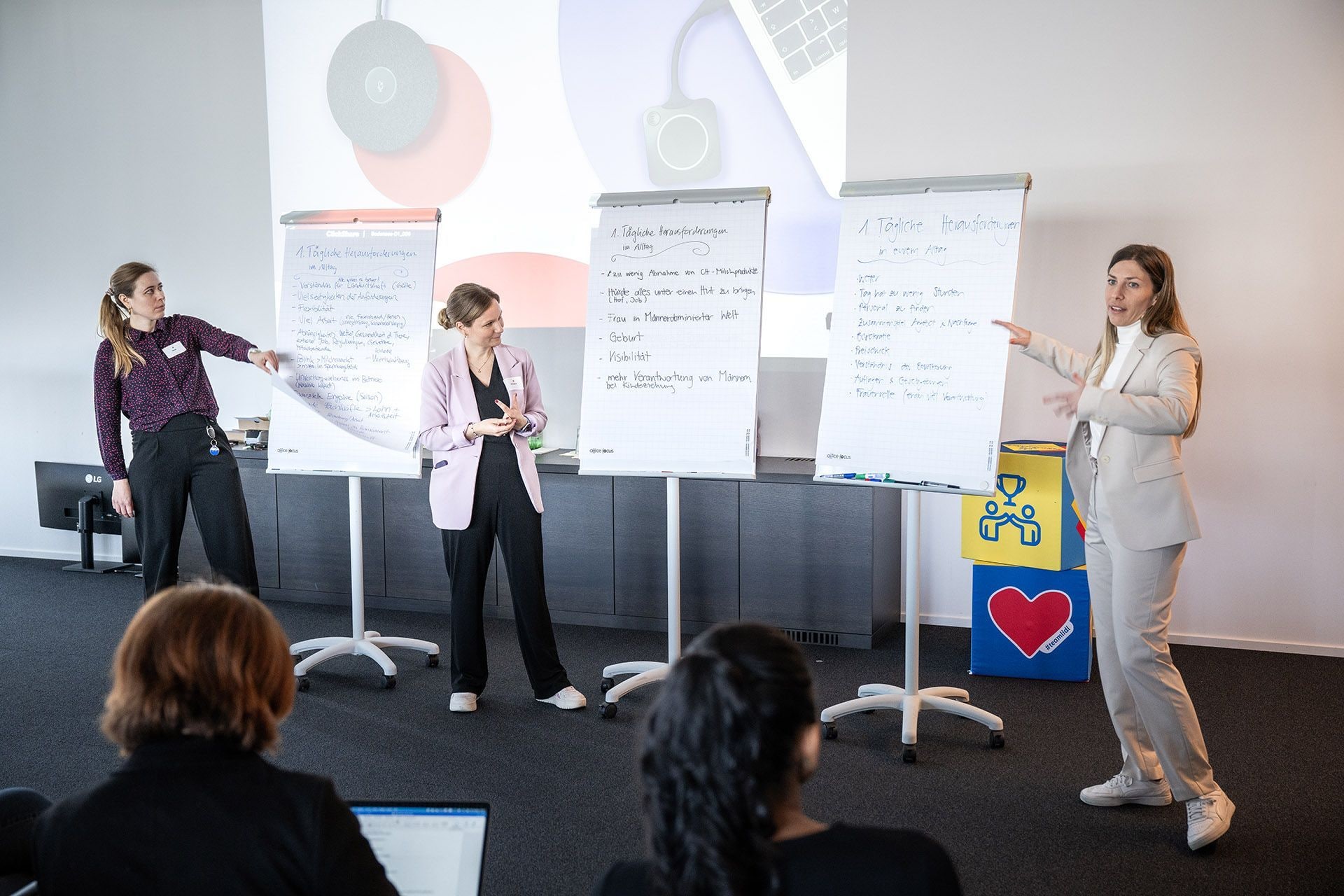 Milena Hermann, Head of Corporate Communications (1. v. r.), präsentiert die spannenden Ergebnisse am Ende des Workshops, während die anderen Teilnehmerinnen zuhören.