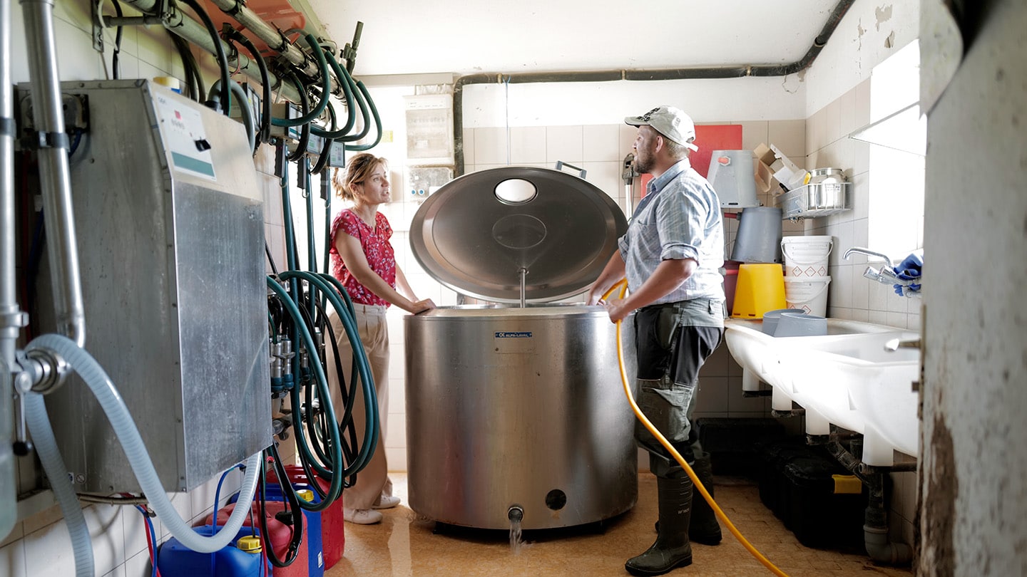 Agroimpact, Aude Jarabo und Christian Tschanz stehen vor Milchtank.