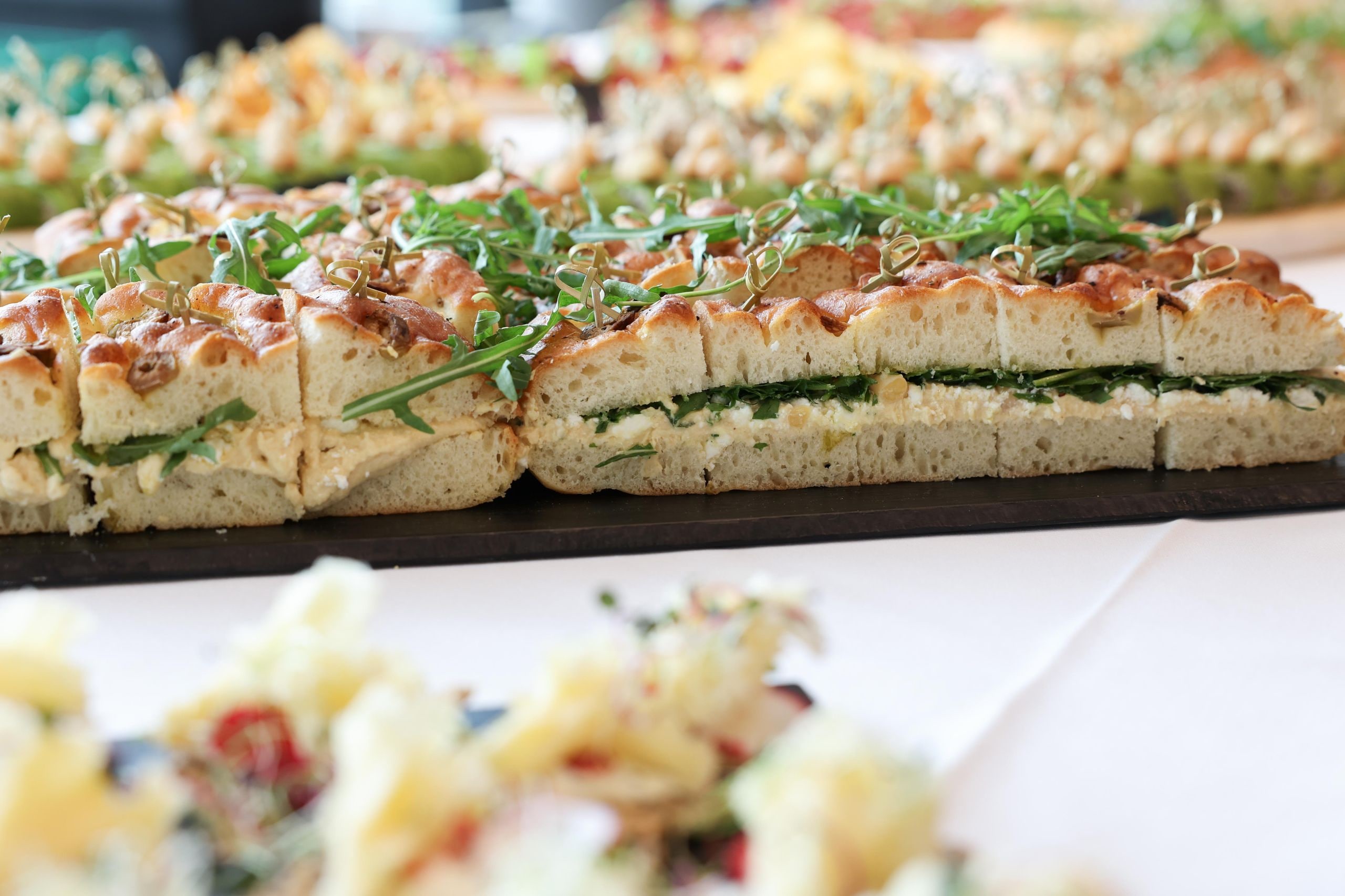 Sandwiches à la focaccia frais avec roquette sur un plateau en ardoise dans le cadre du catering haut de gamme du meeting des parties prenantes de Lidl Suisse.
