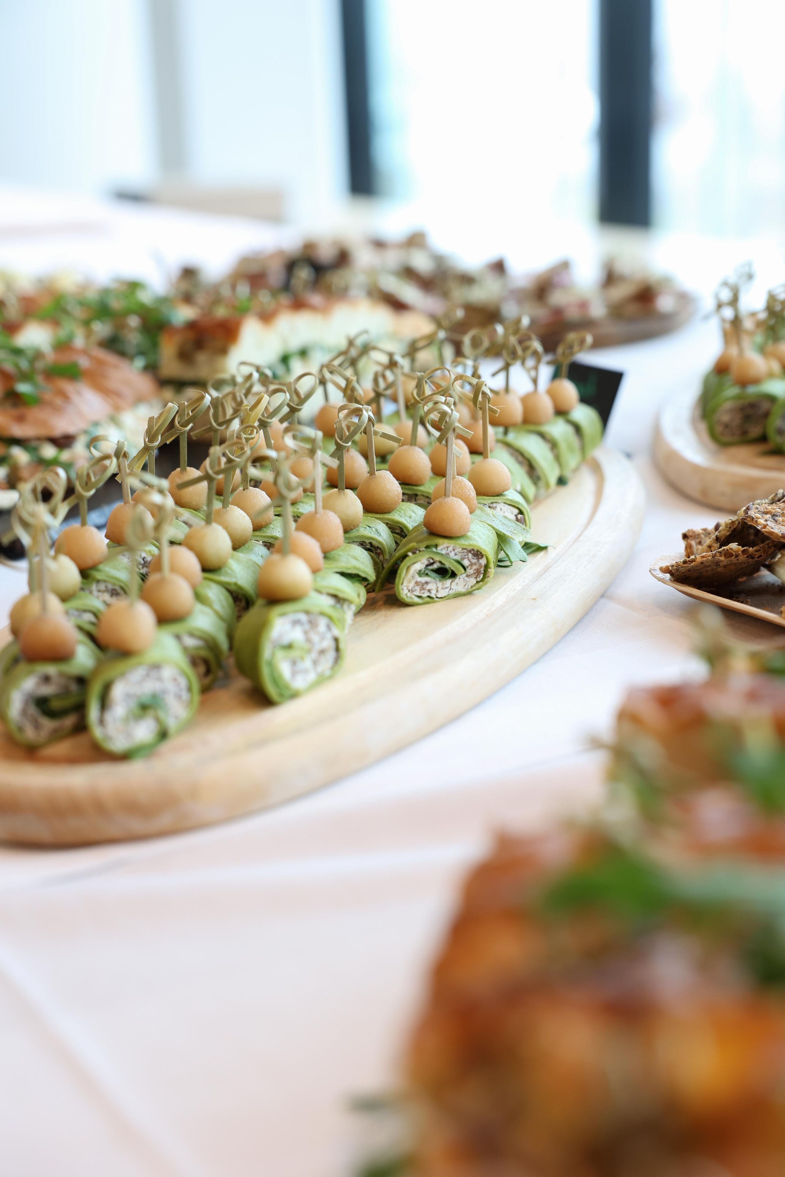 Wraps aux épinards fraîchement préparés avec garniture au fromage frais sur un plateau en bois dans le cadre de l'apéritif du meeting des parties prenantes de Lidl Suisse.
