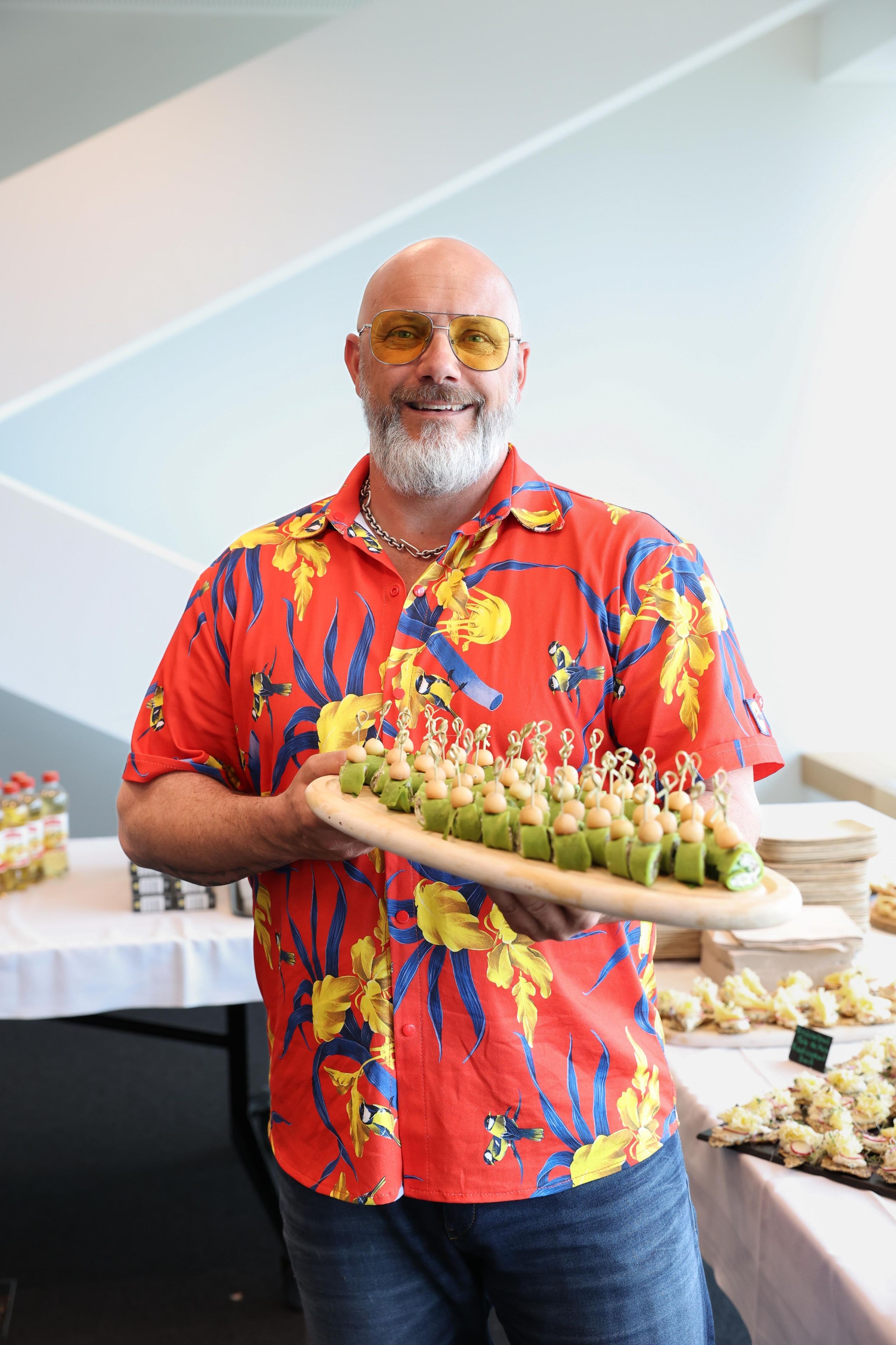 Le chef cuisinier télévisé René Schudel présente en souriant un plateau de wraps aux épinards lors de l'apéritif du meeting des parties prenantes de Lidl Suisse.