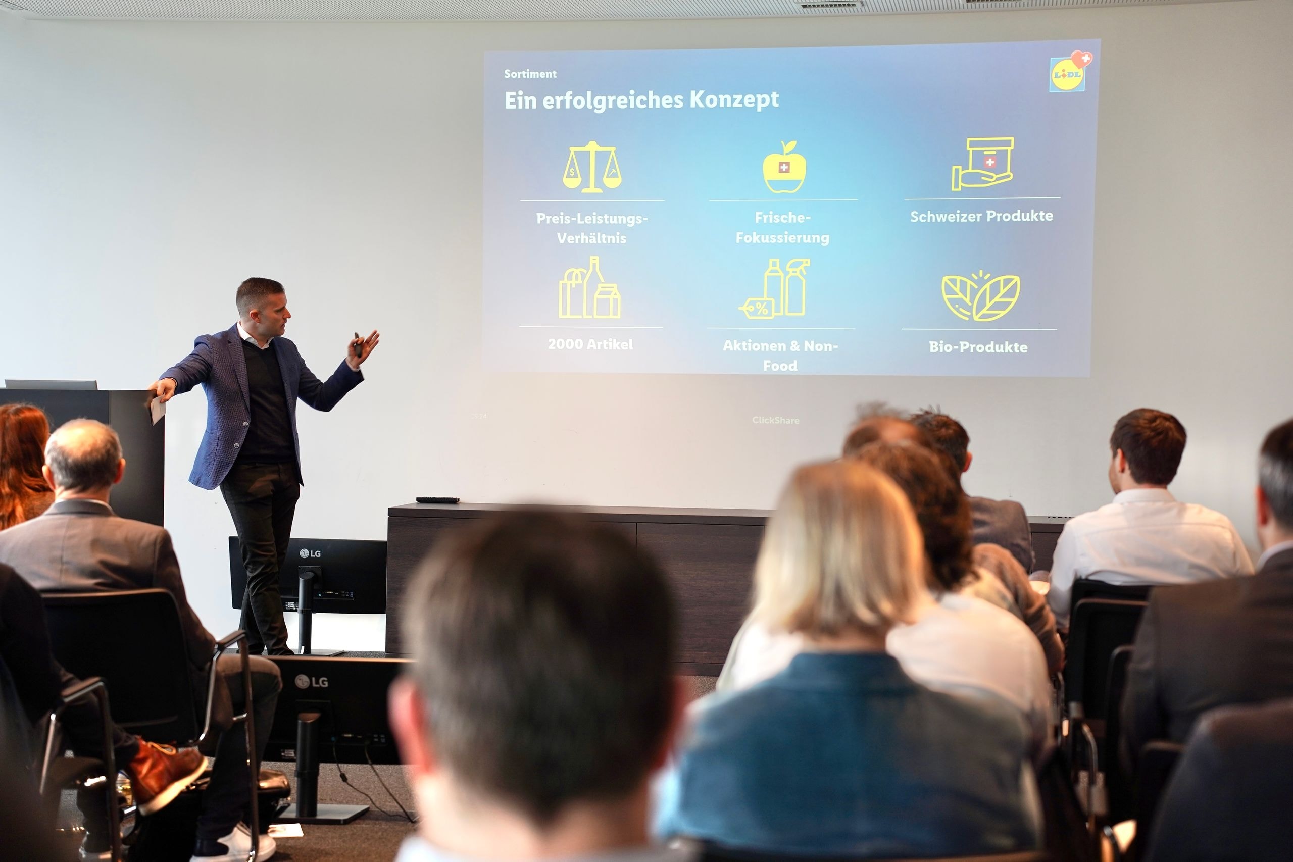 Le CEO de Lidl Suisse Nicholas Pennanen présente le concept d'assortiment axé sur le rapport qualité-prix, la fraîcheur, les produits suisses, les produits bio ainsi que les promotions et les articles non alimentaires devant des parties prenantes.